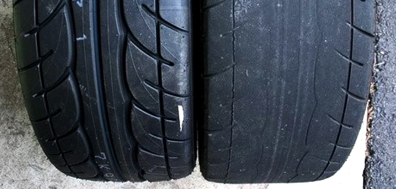 Dois pneus, sendo que o da direita está com desgaste excessivo por conta do alinhamento incorreto.